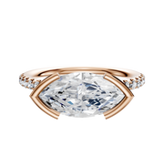 The 18K Rose Gold Bezel Half Bezel East/West Classic Dome 1-Row-Pave 2.5mm Engagement Ring showcases a marquise center stone with round pave diamonds set along the band for extra sparkle.