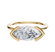 The 18K Yellow Gold Bezel Half Bezel East/West Classic Dome 1.5mm Engagement Ring features a large, horizontally set oval gemstone secured by two curved gold prongs on each end, shown against a white background.