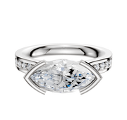A platinum engagement ring featuring a cathedral flat band with half bezel east/west setting and a 2.5mm row of pave diamonds.