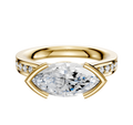 The 18K Yellow Gold Bezel Half Bezel East/West Cathedral Flat 1-Row-Pave 2.5mm Engagement Ring features a unique east/west setting and a row of pave diamonds along the band, crafted in luxurious yellow gold.