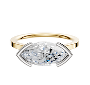 The 18K Two Tone Bezel Half Bezel East/West Cathedral Flat 1.5mm Engagement Ring features a large marquise-cut diamond set horizontally in a white metal prong, showcased on a white background.