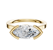 The 18K Yellow Gold Bezel Half Bezel East/West Cathedral Flat 2.0mm Engagement Ring showcases a large marquise-cut clear gemstone set horizontally with modern open-ended prongs, displayed on a plain white background.