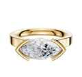 The 18K Yellow Gold Bezel Half Bezel East/West Cathedral Flat 3.0mm Engagement Ring features a large marquise-cut diamond set horizontally in sleek gold prongs, displayed against a white background.