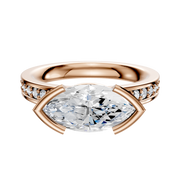 The 14K Rose Gold Bezel Half Bezel East/West Classic Flat 1-Row-Pave 2.5mm Engagement Ring features a central marquise-cut diamond and small round pave diamonds set along the band.