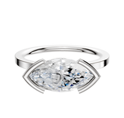 A 14K white gold engagement ring with a classic flat 1.5mm band features an east/west set gemstone in a half bezel setting, shown on a white background.