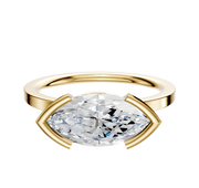 An 18K yellow gold engagement ring, featuring a flat 1.5mm band and a classic half bezel east/west setting, displayed against a plain white background.