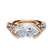 An 18K rose gold cathedral engagement ring with a knife-edge band, featuring a unique east/west bezel setting and a single row of pave-set diamonds along the 2.5mm band.