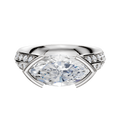 An 18K white gold cathedral knife edge engagement ring with a half bezel east/west setting and a 2.5mm band, featuring one row of pavé diamonds along the band.