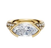 A 14K yellow gold engagement ring with an east/west marquise bezel setting, cathedral knife edge band, and a single row of pave-set diamonds accenting the shank.