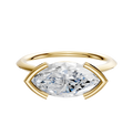 A 14K yellow gold engagement ring with a 1.5mm knife edge band and an east/west marquise-cut diamond in a half bezel cathedral setting, displayed on a plain white background.