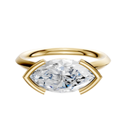 The 14K Yellow Gold Bezel Half Bezel East/West Cathedral Knife Edge 2.0mm Engagement Ring showcases a large marquise-cut diamond set horizontally with prongs, displayed on a plain white background.