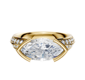 An 18K yellow gold engagement ring featuring a classic knife edge, east/west bezel-set center, and a single row of pave diamonds on the 2.5mm band.