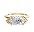 An 18K yellow gold East/West Classic Knife Edge engagement ring featuring a large marquise-cut clear gemstone in a half bezel setting, displayed against a plain white background.