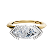 A 14K two-tone engagement ring featuring a classic knife edge and an east/west oval diamond in a distinctive half bezel setting.