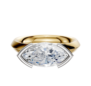 An 18K two-tone engagement ring with a classic knife-edge band and a half bezel east/west setting, featuring a marquise-cut diamond, displayed against a plain white background.