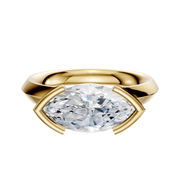 An 18K yellow gold East/West Classic Knife Edge engagement ring featuring a 3.0mm marquise diamond in a modern half bezel setting, shown against a plain white background.