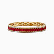 The 18K Yellow Gold Ruby and Diamond Bangle features a honeycomb-patterned interior, with a row of rubies bordered by two rows of sparkling diamonds on the outside.
