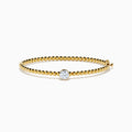 The Star Lab Grown Diamond Beaded Bangle in 18K Yellow Gold features a delicate gold band with beaded accents and a single round, clear lab-grown diamond at the center, shown against a plain white background.