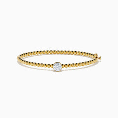 The Star Lab Grown Diamond Beaded Bangle in 18K Yellow Gold features a delicate gold band with beaded accents and a single round, clear lab-grown diamond at the center, shown against a plain white background.