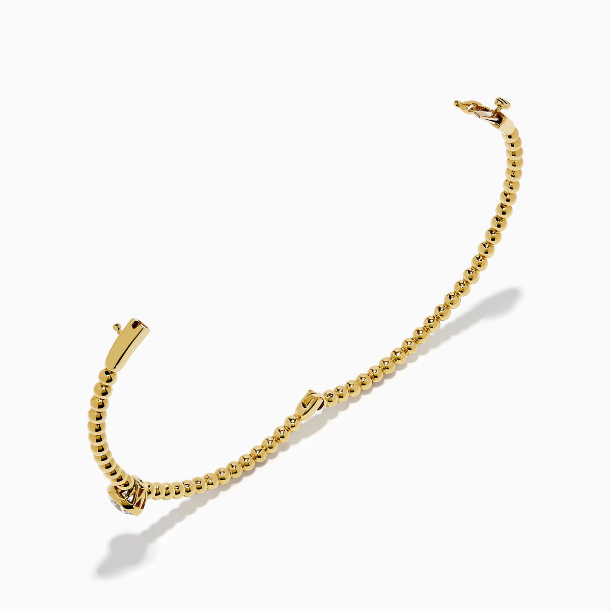 The Star Lab Grown Diamond Beaded Bangle in 18K Yellow Gold features a delicate gold band with beaded accents and a single round, clear lab-grown diamond at the center, shown against a plain white background.