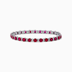 The Ruby Royale 18K White Gold Ruby and Diamond Tennis Bracelet showcases vibrant red rubies in individual prong settings, elegantly displayed against a plain white background.