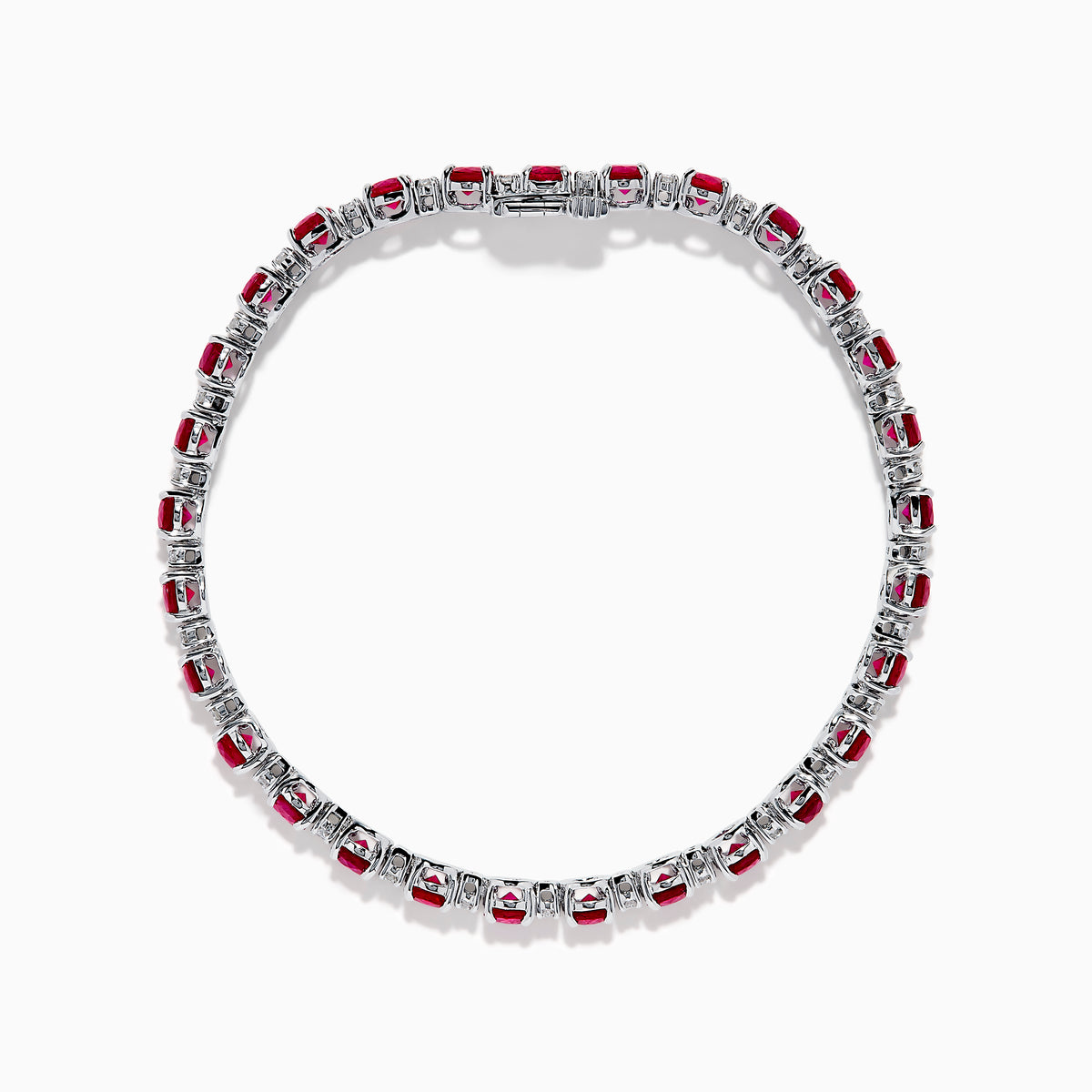 The Ruby Royale 18K White Gold Ruby and Diamond Tennis Bracelet showcases vibrant red rubies in individual prong settings, elegantly displayed against a plain white background.
