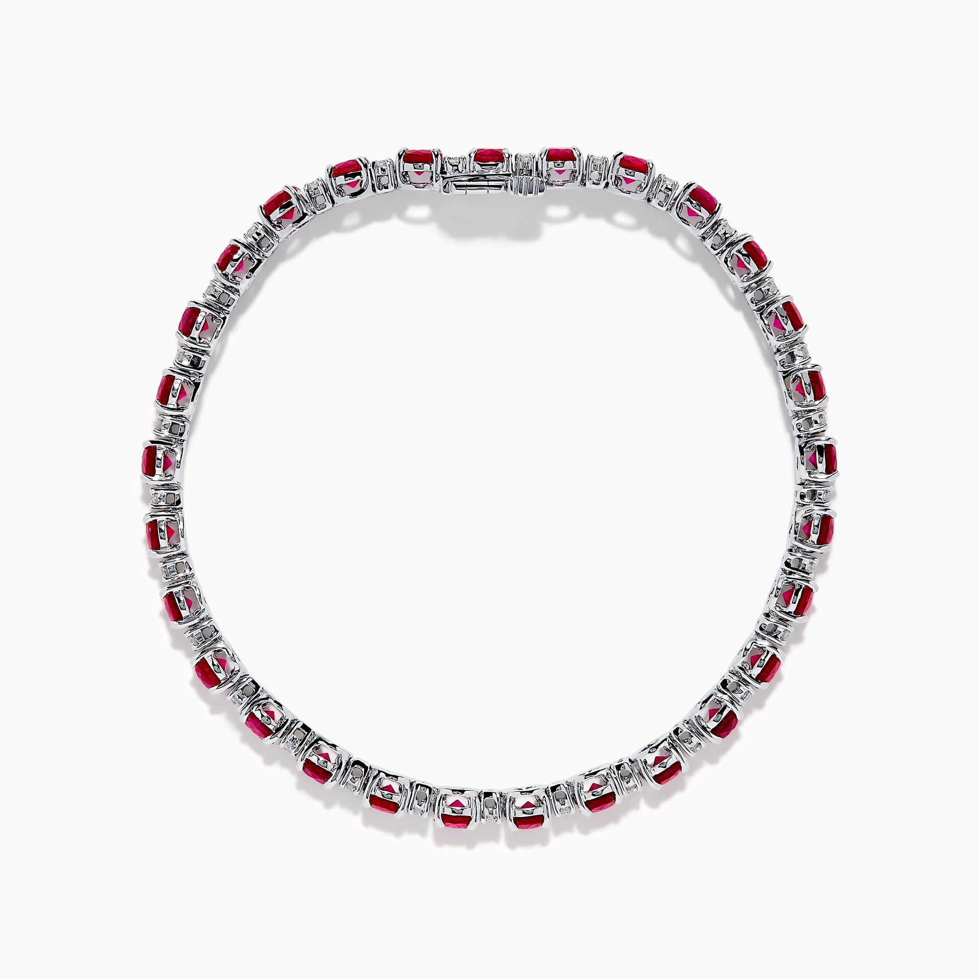 The Ruby Royale 18K White Gold Ruby and Diamond Tennis Bracelet showcases vibrant red rubies in individual prong settings, elegantly displayed against a plain white background.