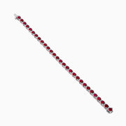 The Ruby Royale 18K White Gold Ruby and Diamond Tennis Bracelet showcases vibrant red rubies in individual prong settings, elegantly displayed against a plain white background.