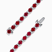 The Ruby Royale 18K White Gold Ruby and Diamond Tennis Bracelet showcases vibrant red rubies in individual prong settings, elegantly displayed against a plain white background.