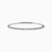 The 14K White Gold Flexible Diamond Bracelet features a slim, elegant design with a single row of sparkling diamonds set around its flexible band, shown against a white background.