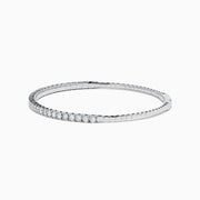 The 14K White Gold Flexible Diamond Bracelet features a slim, elegant design with a single row of sparkling diamonds set around its flexible band, shown against a white background.