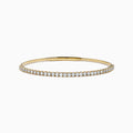 The 14K Yellow Gold Flexible Diamond Bracelet showcases a row of white diamonds on its outer surface, elegantly displayed against a plain white background.