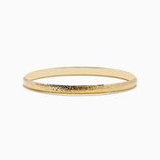 The 14K Yellow Gold Chevron Bangle features a subtle engraved pattern along its outer surface and is displayed on a white background.