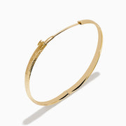 The 14K Yellow Gold Chevron Bangle features a subtle engraved pattern along its outer surface and is displayed on a white background.