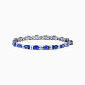 The 14K White Gold Tanzanite and Diamond Tennis Bracelet features alternating oval tanzanite gemstones and sparkling diamonds set against a plain white background.