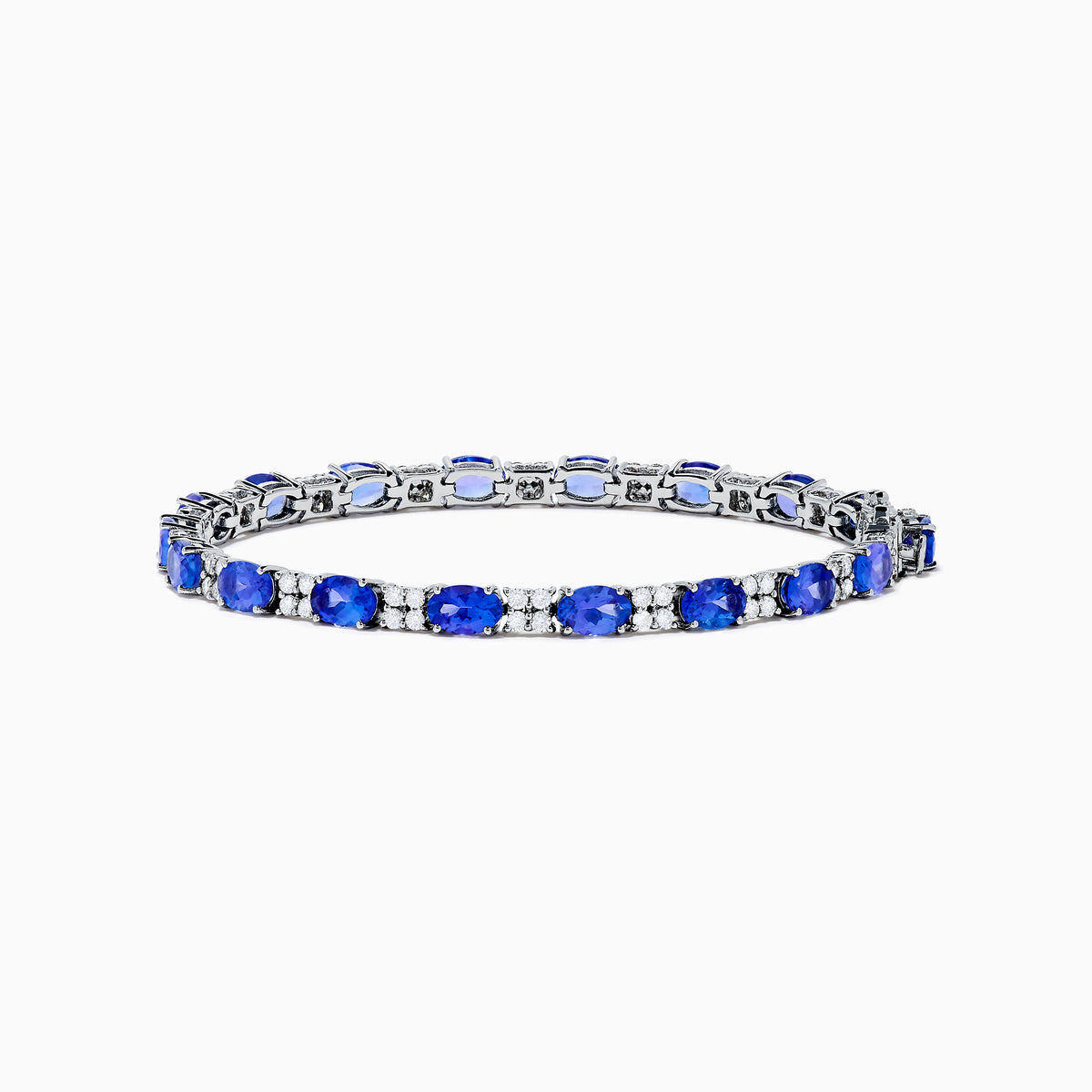 The 14K White Gold Tanzanite and Diamond Tennis Bracelet features alternating oval tanzanite gemstones and sparkling diamonds set against a plain white background.