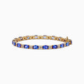 The 14K Yellow Gold Tanzanite and Diamond Tennis Bracelet showcases alternating round blue tanzanites and sparkling diamonds in a single row, secured with a reliable clasp.