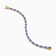 The 14K Yellow Gold Tanzanite and Diamond Tennis Bracelet showcases alternating round blue tanzanites and sparkling diamonds in a single row, secured with a reliable clasp.
