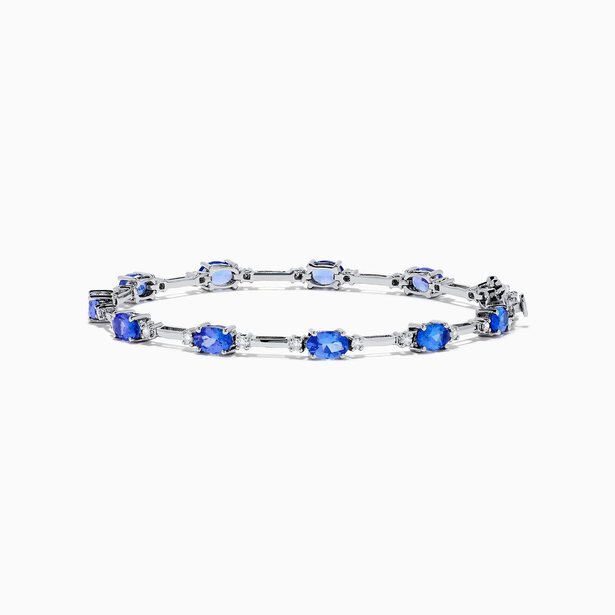 The 14K White Gold Tanzanite and Diamond Station Bracelet features vibrant oval-cut tanzanites and sparkling diamonds evenly spaced along the band, connected by delicate links for a timeless, elegant look.