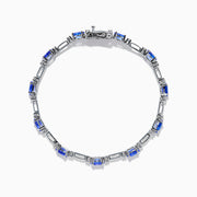 The 14K White Gold Tanzanite and Diamond Station Bracelet features vibrant oval-cut tanzanites and sparkling diamonds evenly spaced along the band, connected by delicate links for a timeless, elegant look.