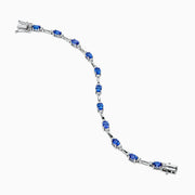 The 14K White Gold Tanzanite and Diamond Station Bracelet features vibrant oval-cut tanzanites and sparkling diamonds evenly spaced along the band, connected by delicate links for a timeless, elegant look.