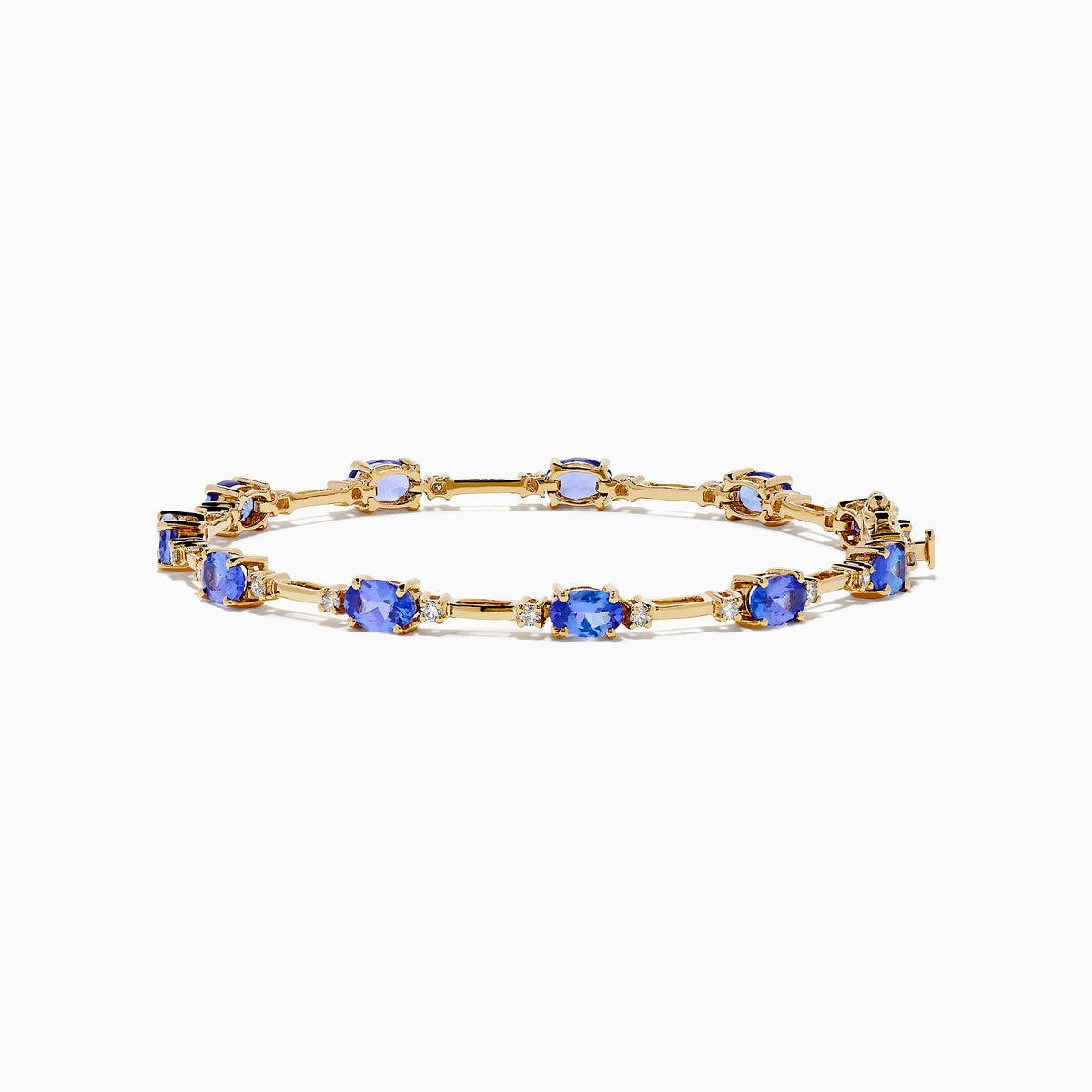 The 14K Yellow Gold Tanzanite and Diamond Station Bracelet showcases evenly spaced oval tanzanites set in gold links, each accented by sparkling diamonds, creating an elegant look against a white background.