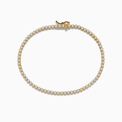 The 14K Yellow Gold Diamond Tennis Bracelet 1.30 TCW features a single row of round white diamonds in prong settings, displayed in a circular shape on a white background.