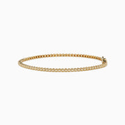 The 14K Yellow Gold 0.25 Ct. Diamond Tennis Bracelet features small, evenly spaced round diamonds and is displayed on a white background.