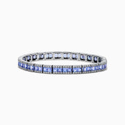 The Nahla Siri 14K White Gold Tanzanite and Diamond Tennis Bracelet features square blue tanzanites bordered by sparkling diamonds, elegantly set in a classic tennis bracelet design.