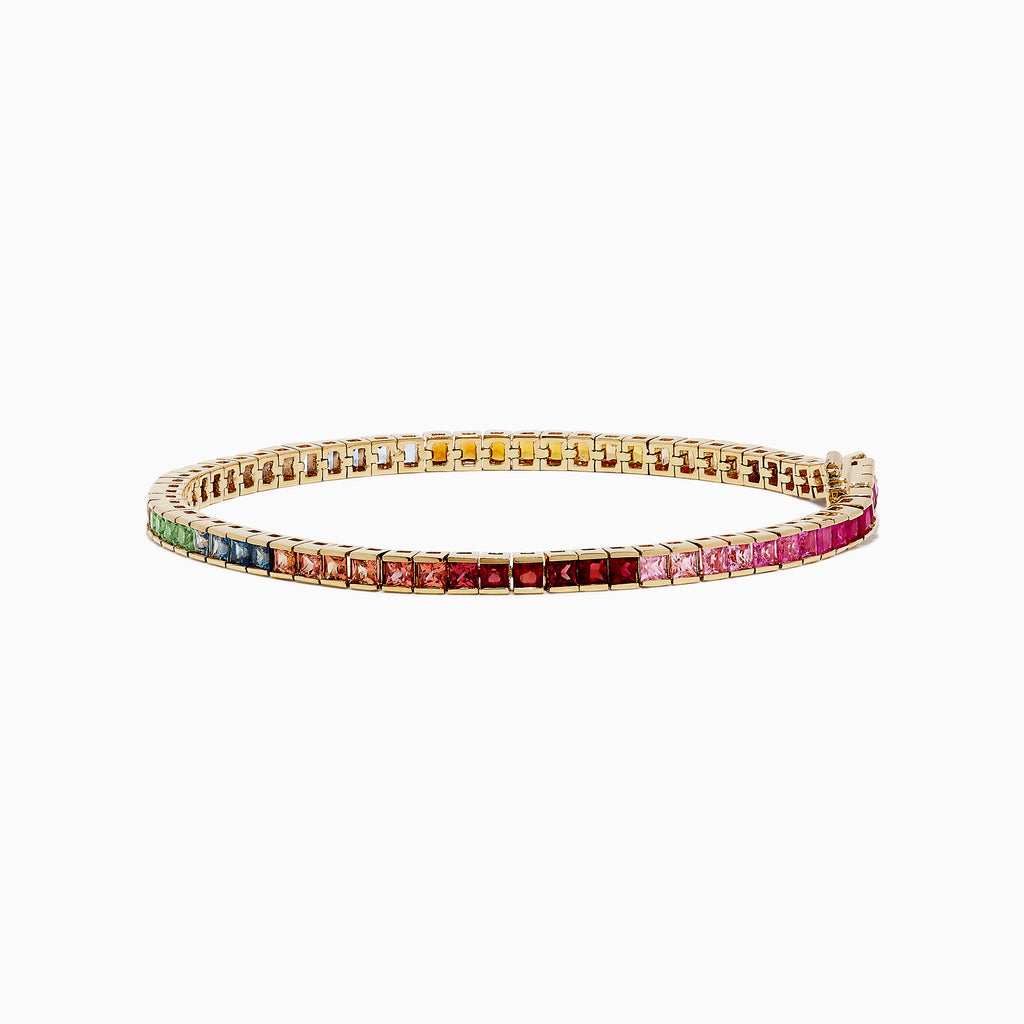 The Watercolors 14K Yellow Gold Multi Sapphire Tennis Bracelet features square-cut sapphires in a rainbow gradient—from green and blue to yellow, orange, red, and pink—set in yellow gold and shown on a white background.