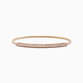 The 14K Rose Gold Flexible Diamond Bangle features a sleek row of sparkling white diamonds along the top, offering a simple, elegant, and symmetrical design with a smooth polished finish.