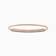 The 14K Rose Gold Flexible Diamond Bangle features a sleek row of sparkling white diamonds along the top, offering a simple, elegant, and symmetrical design with a smooth polished finish.
