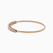 The 14K Rose Gold Flexible Diamond Bangle features a sleek row of sparkling white diamonds along the top, offering a simple, elegant, and symmetrical design with a smooth polished finish.