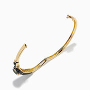 The Signature 14K Yellow Gold Black Diamond Panther Bangle showcases a black panther head with green eyes and a sparkling loop clasp set with small clear stones.